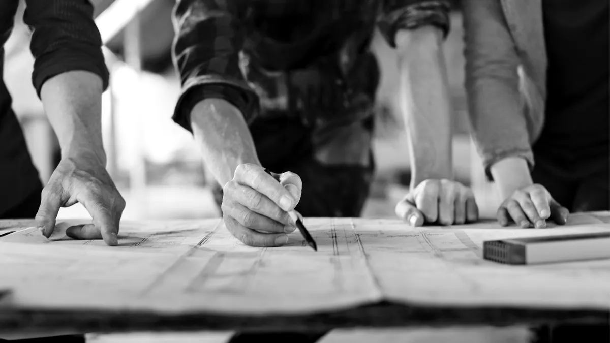 Hands marking up a construction drawing